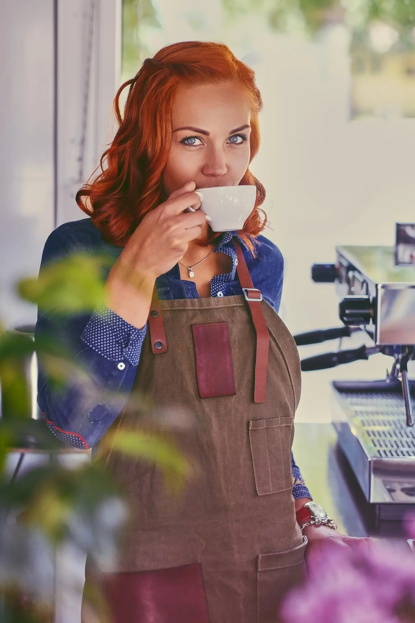 Porträt einer rothaarigen weiblichen Barista in einem kleinen Café.
