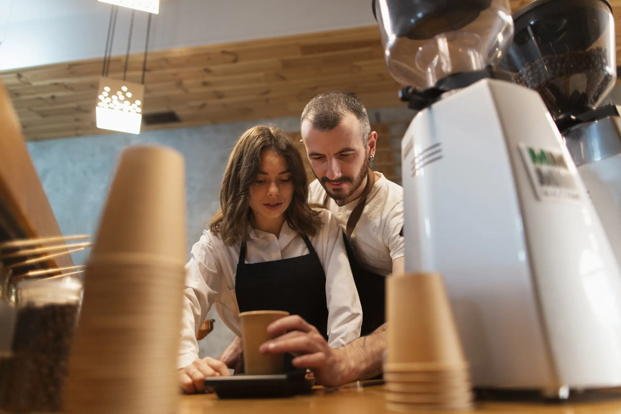 Untersicht eines Paares, das arbeitet und Kaffee zubereitet.